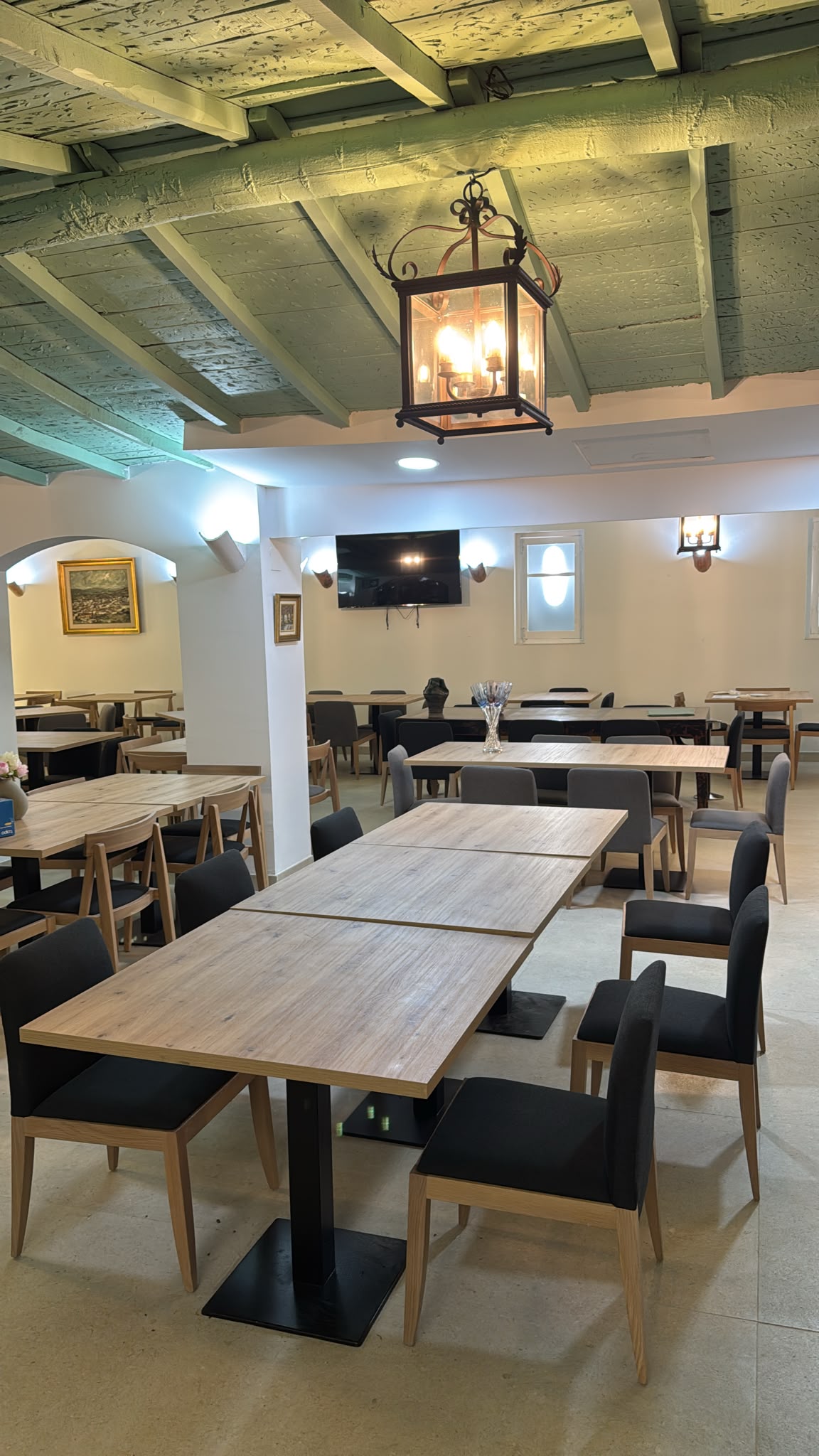 Sala del restaurante Los Pinochos con vigas de madera y farol de forja